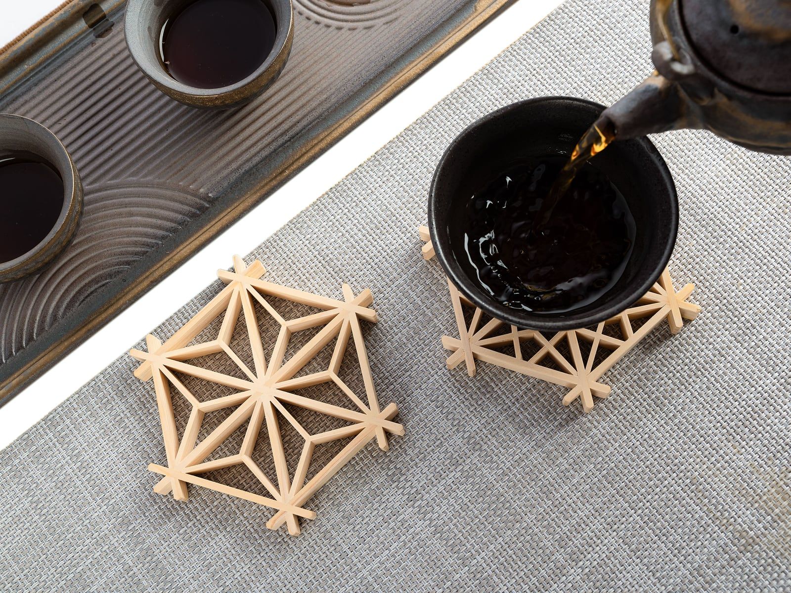 3D-geprinte onderzetters met een geometrisch patroon onder een theekopje